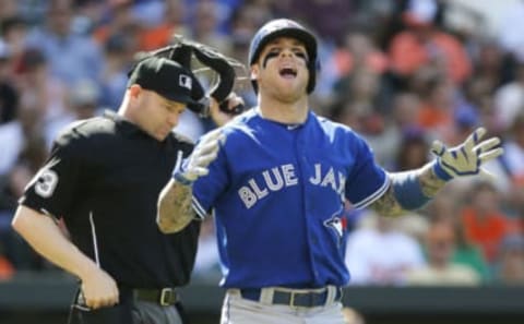 BALTIMORE, MD – JUNE 14: Brett Lawrie #13 of the Toronto Blue Jays reacts after being hit by a pitch from Bud Norris #25 of the Baltimore Orioles during the second inning of their game at Oriole Park at Camden Yards on June 14, 2014 in Baltimore, Maryland. Also pictured is home plate umpire Mike Estabrook. (Photo by Jonathan Ernst/Getty Images)