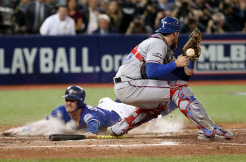 TORONTO, ON – OCTOBER 9: Josh Donaldson #20 of the Toronto Blue Jays slides safely into home plate past Jonathan Lucroy #25 of the Texas Rangers in the tenth inning for the Toronto Blue Jays to defeat the Texas Rangers 7-6 for game three of the American League Division Series at Rogers Centre on October 9, 2016 in Toronto, Canada. (Photo by Tom Szczerbowski/Getty Images)