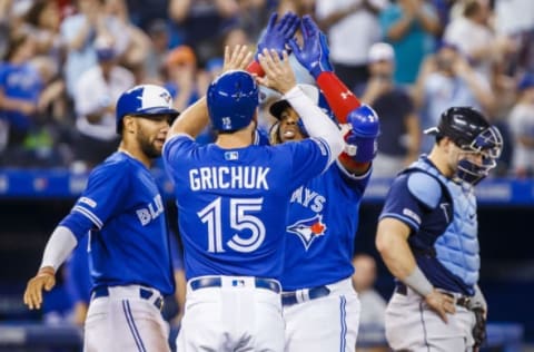 TORONTO, ONTARIO – JULY 27: Vladimir Guerrero Jr. #27 of the Toronto Blue Jays celebrates his three run home run with teammates Randal Grichuk #15, and Lourdes Gurriel Jr. #13 against the Tampa Bay Rays in the ninth inning during their MLB game at the Rogers Centre on July 27, 2019 in Toronto, Canada. (Photo by Mark Blinch/Getty Images)