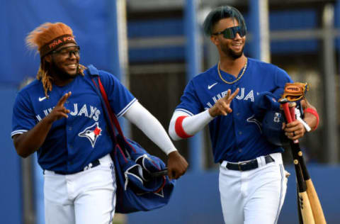 Mar 26, 2021; Dunedin, Florida, USA; Toronto Blue Jays designated hitter Vladimir Guerrero Jr. (27) and outfielder Lourdes Gurriel Jr. (13) walk onto the field before the start of the game against the Philadelphia Phillies during spring training at TD Ballpark. Mandatory Credit: Jonathan Dyer-USA TODAY Sports