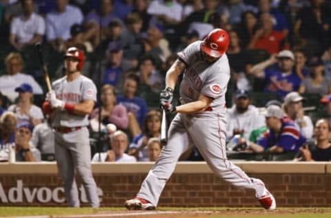 Sep 7, 2021; Chicago, Illinois, USA; Cincinnati Reds second baseman Mike Moustakas (9) hits an RBI single against the Chicago Cubs during the eight inning at Wrigley Field. Mandatory Credit: Kamil Krzaczynski-USA TODAY Sports