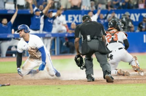 Aug 17, 2022; Toronto, Ontario, CAN; Toronto Blue Jays pinch hitter George Springer (4) slides into home plate and celebrates scoring a run against the Baltimore Orioles during the seventh inning at Rogers Centre. Mandatory Credit: Nick Turchiaro-USA TODAY Sports