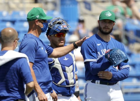 Mar 17, 2021; Dunedin, Florida, USA; Toronto Blue Jays starting pitcher Thomas Hatch (31) grabs his arm as pitching coach Pete Walker (40) comes to the mound as Hatch leaves the game during the third inning against the New York Yankees at TD Ballpark. Mandatory Credit: Kim Klement-USA TODAY Sports