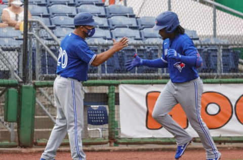 Mar 29, 2021; Clearwater, Florida, USA; Toronto Blue Jays Orelvis Martinez (95) is congratulated by third base coach Luis Rivera (20) after hitting a home run during the sixth inning against the Philadelphia Phillies at BayCare Ballpark. Mandatory Credit: Mike Watters-USA TODAY Sports