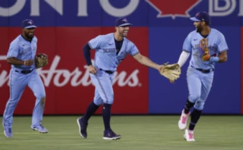 May 18, 2021; Dunedin, Florida, CAN; Toronto Blue Jays right fielder Teoscar Hernandez (37), center fielder Randal Grichuk (15) and left fielder Lourdes Gurriel Jr. (13) celebrate as they beat the Boston Red Sox at TD Ballpark. Mandatory Credit: Kim Klement-USA TODAY Sports