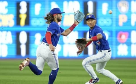 Apr 27, 2022; Toronto, Ontario, CAN; Toronto Blue Jays shortstop Bo Bichette (11) catches a ground ball hit by Boston Red Sox shortstop Xander Bogaerts (not pictured) as Toronto Blue Jays second baseman Gosuke Katoh (29) follows up during the first inning at Rogers Centre. Mandatory Credit: John E. Sokolowski-USA TODAY Sports