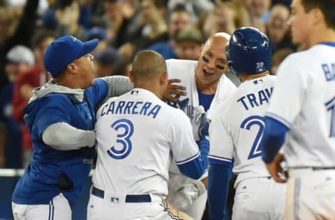 May 10, 2017; Toronto, Ontario, CAN; Toronto Blue Jays shortstop Ryan Goins (center) is mobbed by teammates after driving in the winning run in the ninth inning to give the Jays an 8-7 victory over the Cleveland Indians at Rogers Centre. Mandatory Credit: Dan Hamilton-USA TODAY Sports