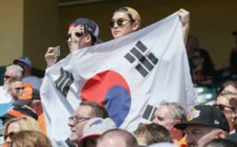 Mar 1, 2016; Lake Buena Vista, FL, USA; Fans hold up a South Korean flag as a tribute to Baltimore Orioles outfielder Hyun Soo Kim (25) during the second inning of a spring training baseball game against the Atlanta Braves at Champion Stadium. Mandatory Credit: Reinhold Matay-USA TODAY Sports