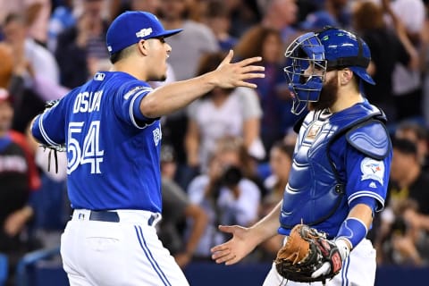 Oct 18, 2016; Toronto, Ontario, CAN; Toronto Blue Jays relief pitcher Roberto Osuna (54) celebrates with catcher Russell Martin (55) after beating the Cleveland Indians in game four of the 2016 ALCS playoff baseball series at Rogers Centre. Mandatory Credit: Nick Turchiaro-USA TODAY Sports