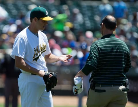 Jul 17, 2016; Oakland, CA, USA; Oakland Athletics starting pitcher Rich Hill (18) is visited by a trainer to look at his hand during the first inning against the Toronto Blue Jays at O.co Coliseum. Mandatory Credit: Kelley L Cox-USA TODAY Sports