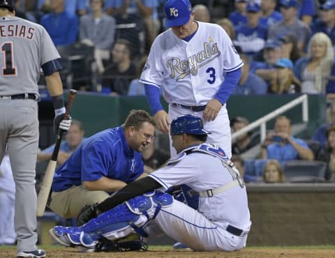 Sep 2, 2016; Kansas City, MO, USA; Kansas City Royals athletic trainer Kyle Turner and manager Ned Yost (3) take a look at catcher Salvador Perez (13) after an injury in the ninth inning against the Detroit Tigers at Kauffman Stadium. The Tigers won 7-6. Mandatory Credit: Denny Medley-USA TODAY Sports