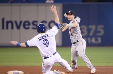 TORONTO, ON – SEPTEMBER 25: Alex Bregman #2 of the Houston Astros turns a double play in the fifth inning during MLB game action as Danny Jansen #9 of the Toronto Blue Jays slides into second base at Rogers Centre on September 25, 2018 in Toronto, Canada. (Photo by Tom Szczerbowski/Getty Images)