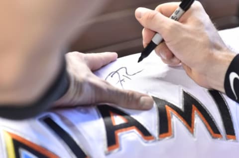 MIAMI, FL – SEPTEMBER 23: JT Riddle #10 of the Miami Marlins autographs his jersey. (Photo by Eric Espada/Getty Images)