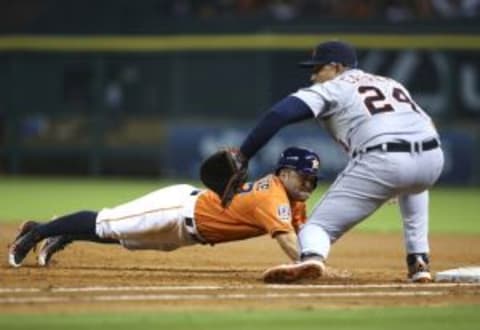 Aug 14, 2015; Houston, TX, USA; Houston Astros second baseman Jose Altuve (27) dives into first base on a pickoff attempt during the third inning as Detroit Tigers first baseman Miguel Cabrera (24) fields the throw at Minute Maid Park. Mandatory Credit: Troy Taormina-USA TODAY Sports