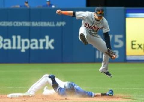 Aug 29, 2015; Toronto, Ontario, CAN; Detroit Tigers shortstop Jose Iglesias (1) leaps over Toronto Blue Jays third baseman Josh Donaldson (20) during the sixth inningat Rogers Centre. Mandatory Credit: Dan Hamilton-USA TODAY Sports