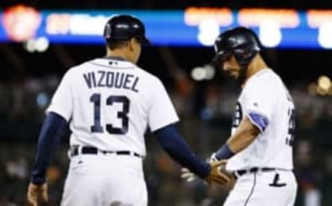 Jul 19, 2016; Detroit, MI, USA; Detroit Tigers right fielder Mike Aviles (14) receives congratulations from first base coach Omar Vizquel (13) after he hits a single in the ninth inning makes a throw at Comerica Park. Mandatory Credit: Rick Osentoski-USA TODAY Sports