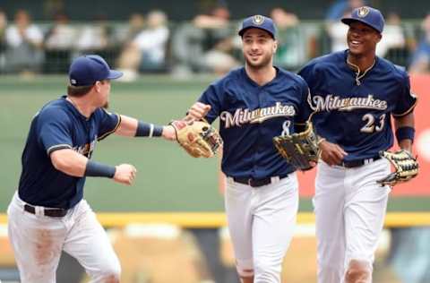 Jun 12, 2016; Milwaukee, WI, USA; Milwaukee Brewers left fielder Ryan Braun (8) is greeted by second baseman Scooter Gennett (2) and center fielder Keon Broxton (23) after making a diving catch of ball hit by New York Mets third baseman Wilmer Flores (4) in the eighth inning at Miller Park. The Brewers beat the Mets 5-3. Mandatory Credit: Benny Sieu-USA TODAY Sports