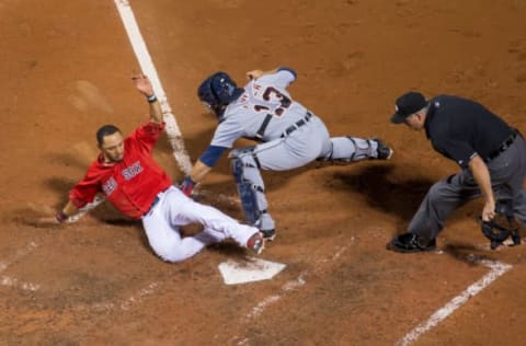 BOSTON, MA – JULY 24: Mookie Betts #50 of the Boston Red Sox slides as he avoids the tag by Alex Avila #13 of the Detroit Tigers at home plate as he scored the winning run during the eleventh inning on a single by Xander Bogaerts #2 at Fenway Park on July 24, 2015 in Boston, Massachusetts. The Red Sox won 2-1. (Photo by Rich Gagnon/Getty Images)