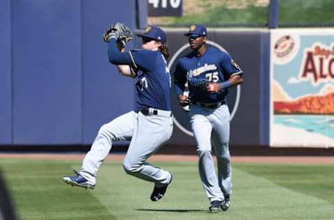 PEORIA, AZ – MARCH 02: Brett Phillips #77 of the Milwaukee Brewers throws the ball to third base as teammate Lewis Brinson #75 looks on during the second inning against the Seattle Mariners at Peoria Stadium on March 2, 2017 in Peoria, Arizona. (Photo by Norm Hall/Getty Images)