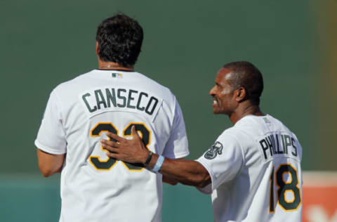 OAKLAND, CA – JULY 19: Jose Canseco #33 gets a pat on the back from Tony Phillips #18 of the 1989 Oakland A’s as they celebrate their World Series championship 25 years ago, before a game against the Baltimore Orioles at O.co Coliseum on July 19, 2014 in Oakland, California. (Photo by Brian Bahr/Getty Images)