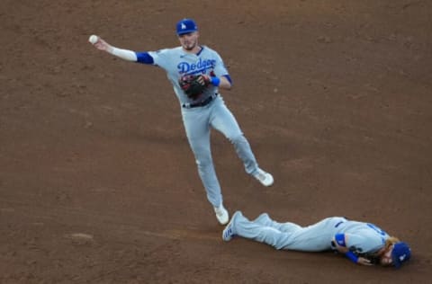 Jul 16, 2021; Denver, Colorado, USA; Los Angeles Dodgers short stop Gavin Lux (9) fields the ball over third baseman Justin Turner (10) in the fourth inning against the Colorado Rockies at Coors Field. Mandatory Credit: Ron Chenoy-USA TODAY Sports