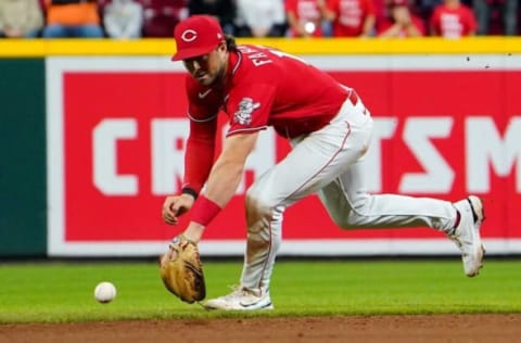 Reds shortstop Kyle Farmer reaches for a ball.