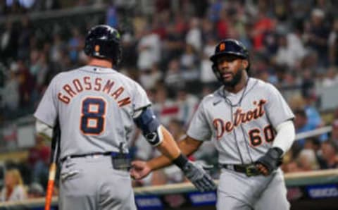 Detroit Tigers outfielder Akil Baddoo (60) celebrates his run with outfielder Robbie Grossman (8) against the Minnesota Twins in the ninth inning at Target Field. Mandatory Credit: Brad Rempel-USA TODAY Sports