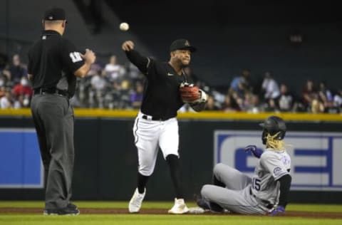 Oct 2, 2021; Phoenix, Arizona, USA; Arizona Diamondbacks second baseman Ketel Marte (4) turns the double play while avoiding Colorado Rockies left fielder Raimel Tapia (15) during the third inning at Chase Field. Mandatory Credit: Rick Scuteri-USA TODAY Sports