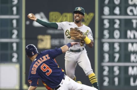 Oct 3, 2021; Houston, Texas, USA; Houston Astros first baseman Marwin Gonzalez (9) is out at second base as Oakland Athletics second baseman Tony Kemp (5) throws to first base during the seventh inning at Minute Maid Park. Mandatory Credit: Troy Taormina-USA TODAY Sports