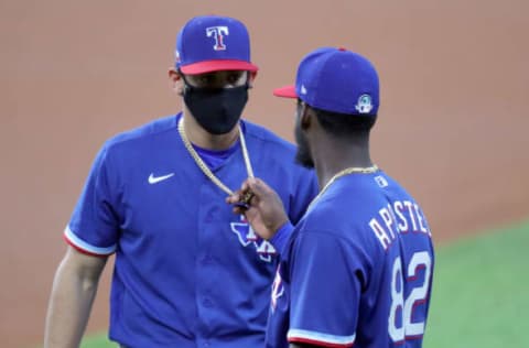 ARLINGTON, TEXAS – JULY 09: Sherten Apostel #82 of the Texas Rangers inspects the necklace of Ronald Guzman #11 of the Texas Rangers before an intrasquad game during Major League Baseball summer workouts at Globe Life Field on July 09, 2020 in Arlington, Texas. (Photo by Tom Pennington/Getty Images)