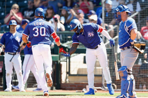 SURPRISE, ARIZONA – MARCH 31: Adolis Garcia #53 of the Texas Rangers high fives Nathaniel Lowe #30 after Lowe hit a home run against the Los Angeles Dodgers during the third inning of the MLB spring training game at Surprise Stadium on March 31, 2022 in Surprise, Arizona. (Photo by Christian Petersen/Getty Images)