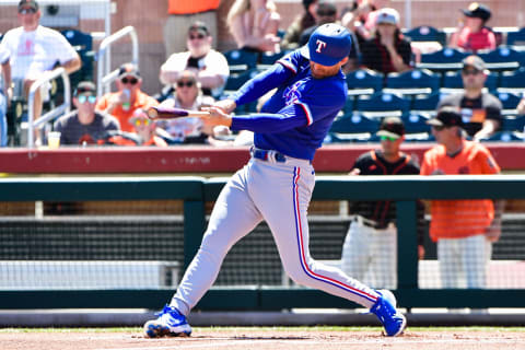 Apr 1, 2022; Scottsdale, Arizona, USA; Texas Rangers second baseman Brad Miller (13) singles in the first inning against the San Francisco Giants at Scottsdale Stadium. Mandatory Credit: Matt Kartozian-USA TODAY Sports