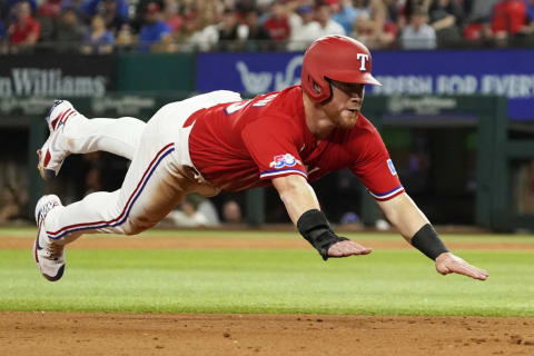 Jun 3, 2022; Arlington, Texas, USA; Texas Rangers right fielder Kole Calhoun (56) dives into third base on a fielders choice against the Seattle Mariners during the sixth inning at Globe Life Field. Mandatory Credit: Raymond Carlin III-USA TODAY Sports