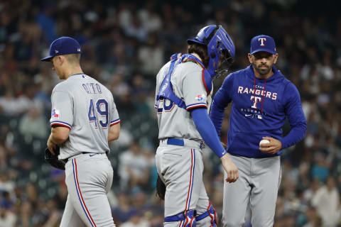 Jul 25, 2022; Seattle, Washington, USA; Texas Rangers starting pitcher Glenn Otto (49) walks to the dugout after handing over the game ball to manager Chris Woodward (8) during a sixth inning pitching change against the Seattle Mariners at T-Mobile Park. Texas Rangers catcher Jonah Heim (28) stands on the mound with Woodward. Mandatory Credit: Joe Nicholson-USA TODAY Sports