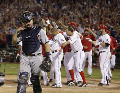 Tigers catcher Alex Avila walks away as the celebrating Texas Rangers wait at home plat for Nelson Cruz after his grand slam won the game in the 11th inning in Game 2 of ALCS In Arlington, Texas, on Monday, Oct. 10, 2011.Tigers 101011 Jhg42