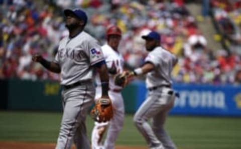 Apr 10, 2016; Anaheim, CA, USA; Texas Rangers shortstop Hanser Alberto (left) reacts after he is unable to complete a pass to shortstop Elvis Andrus (right) to force out Los Angeles Angels right fielder Kole Calhoun (center) during the second inning at Angel Stadium of Anaheim. Mandatory Credit: Kelvin Kuo-USA TODAY Sports