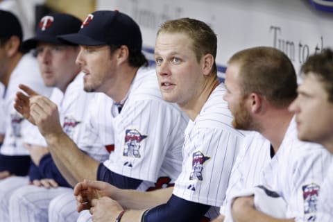 Justin Morneau #33 of the Minnesota Twins talks on the bench as he sits by Joe Nathan #36 (Photo by Bruce Kluckhohn/Getty Images)