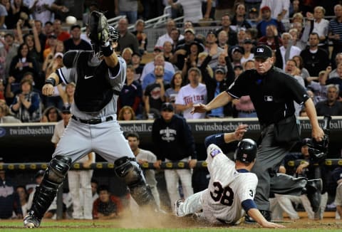 Luke Hughes of the Minnesota Twins slides in safely as A.J. Pierzynski of the Chicago White Sox. (Photo by Hannah Foslien/Getty Images)