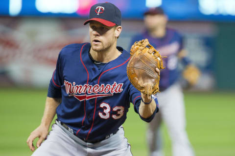 Justin Morneau of the Minnesota Twins fields a ground ball hit by Michael Bourn. (Photo by Jason Miller/Getty Images)