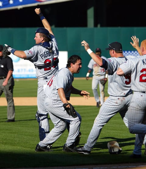 Minnesota Twins’ closing pitcher Eddie Guardado celebrates with teammates A.J. Pierzynski, and Michael Cuddyer (Photo by – / AFP via Getty Images)