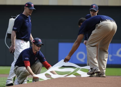 MINNESOTA, MN – APRIL 12: The grounds crew of the Minnesota Twins lay down a logo template on the mound prior to a game between the Minnesota Twins and the Boston Red Sox during the Twins home opener at Target Field on April 12, 2010 in Minneapolis, Minnesota. (Photo by Hannah Foslien /Getty Images)