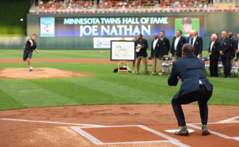 Minnesota Twins Hall of Fame inductee Joe Nathan catches a pitch from his son during a ceremony before the game against the Kansas City Royals. (Photo by Adam Bettcher/Getty Images)