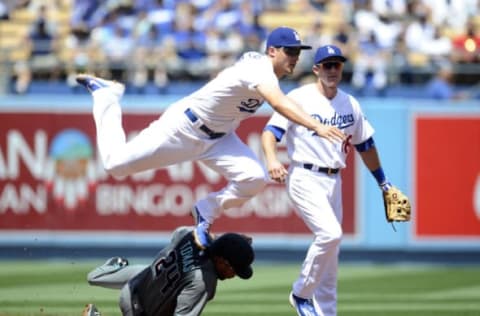 April 16, 2017; Los Angeles, CA, USA; Los Angeles Dodgers shortstop Corey Seager (5) throws to first to turn a double play as he leaps over Arizona Diamondbacks right fielder Yasmany Tomas (24) in the second inning at Dodger Stadium. Mandatory Credit: Gary A. Vasquez-USA TODAY Sports