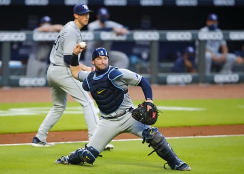 ATLANTA, GA – JULY 30: Catcher Mike Zunino #10 of the Tampa Bay Rays throws to first base for the out in the sixth inning against the Atlanta Braves at Truist Park on July 30, 2020 in Atlanta, Georgia. Zunino returns in 2021 needing a big performance turnaround to save his starting job. (Photo by Todd Kirkland/Getty Images)