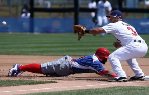 Jul 16, 2015; Toronto, Ontario, CAN; Dominican Republic designated hitter Ruben Sosa (2) dives back to first base on a pick-off attempt in the first inning as United States first baseman Jacob Wilson (3) waits for the throw during the 2015 Pan Am Games at Ajax Pan Am Ballpark. Mandatory Credit: Tom Szczerbowski-USA TODAY Sports