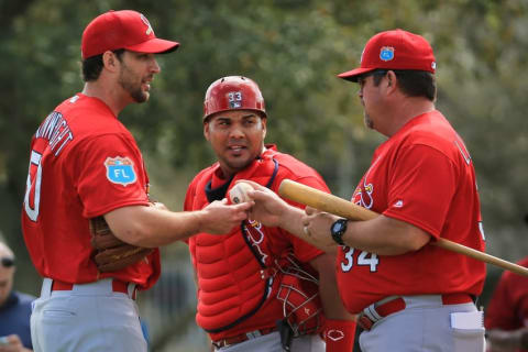 Feb 18, 2016; Jupiter, FL, USA; St. Louis Cardinals starting pitcher Adam Wainwright (left) listens to pitching coach Derek Lilliquist (right) as catcher Brayan Pena (center) listens in at Roger Dean Stadium. Mandatory Credit: Steve Mitchell-USA TODAY Sports