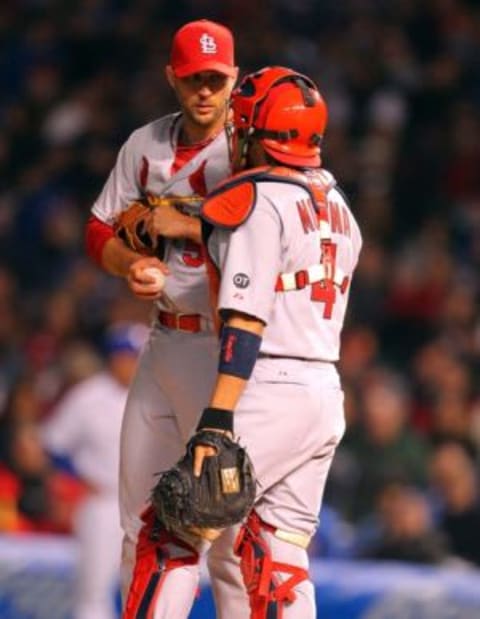 Apr 5, 2015; Chicago, IL, USA; St. Louis Cardinals starting pitcher Adam Wainwright (50) and catcher Yadier Molina (4) meet on the mound during the third inning against the Chicago Cubs at Wrigley Field. Mandatory Credit: Dennis Wierzbicki-USA TODAY Sports