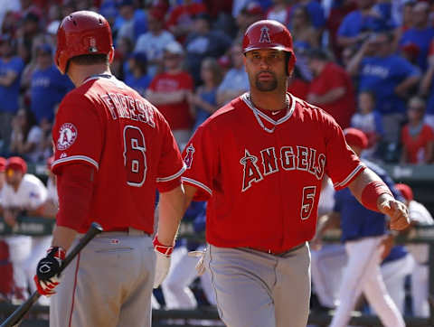 Oct 3, 2015; Arlington, TX, USA; Los Angeles Angels designated hitter Albert Pujols (5) celebrates his run with third baseman David Freese (6) against the Texas Rangers during the ninth inning of a baseball game at Globe Life Park in Arlington. The Angels won 11-10. Mandatory Credit: Jim Cowsert-USA TODAY Sports