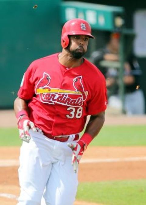 Mar 3, 2016; Jupiter, FL, USA; St. Louis Cardinals right fielder Carlos Peguero (38) connects for an RBI double agents the Miami Marlins during a spring training game at Roger Dean Stadium. Mandatory Credit: Steve Mitchell-USA TODAY Sports