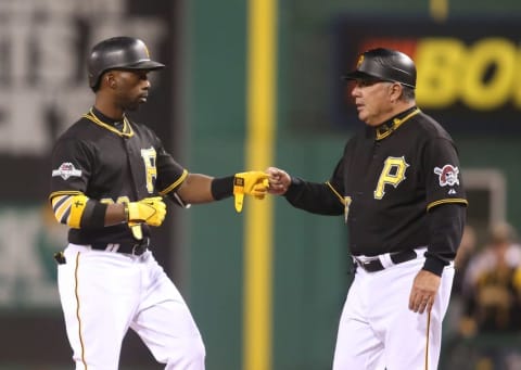 Oct 7, 2015; Pittsburgh, PA, USA; Pittsburgh Pirates center fielder Andrew McCutchen (left) fist bumps first base coach Nick Leyva (16) after McCutchen hit a single against the Chicago Cubs during the first inning in the National League Wild Card playoff baseball game at PNC Park. The Cubs won 4-0. Mandatory Credit: Charles LeClaire-USA TODAY Sports